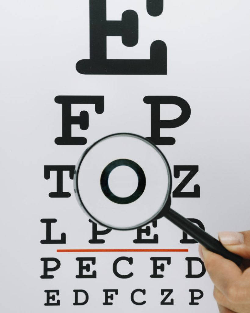 person-holding-magnifying-glass-letters